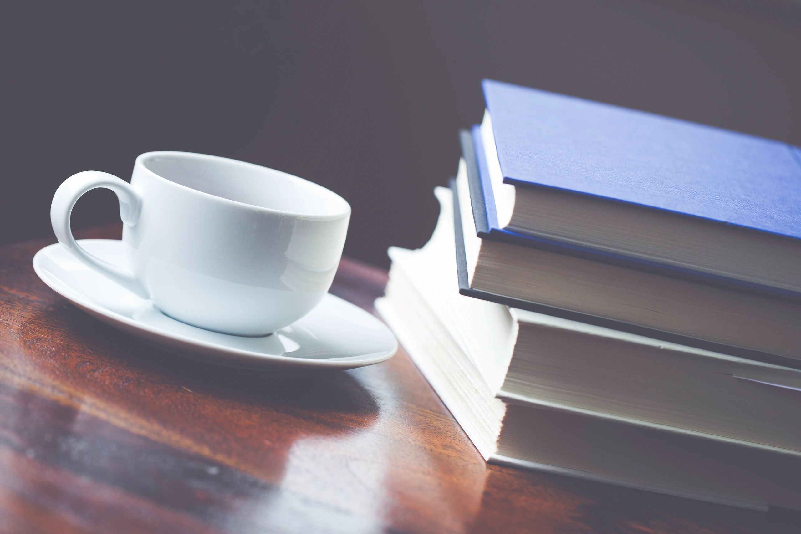 Coffee beside stacked books